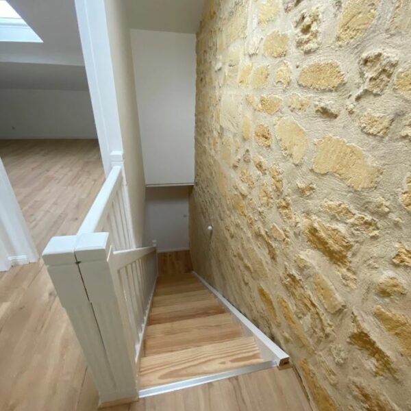 Escalier intérieur rénové avec mur en moellons à Bordeaux
