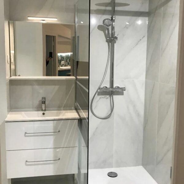 Salle de bain rénovée avec douche italienne et meuble vasque suspendu