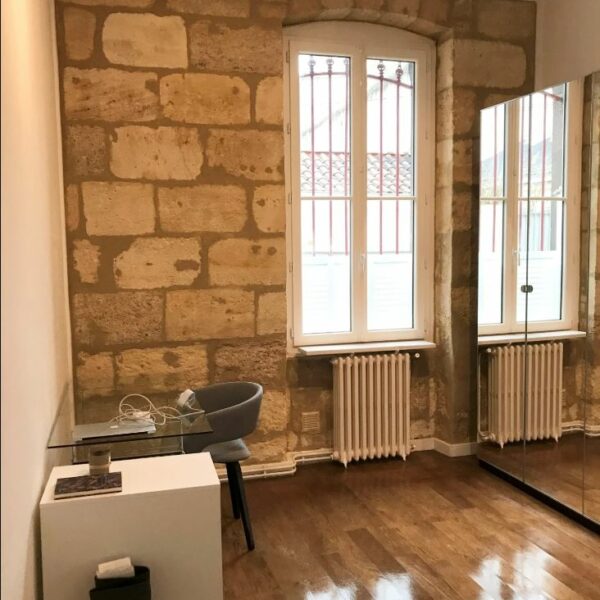 Chambre ou bureau avec parquet brillant et mur en pierre rénové