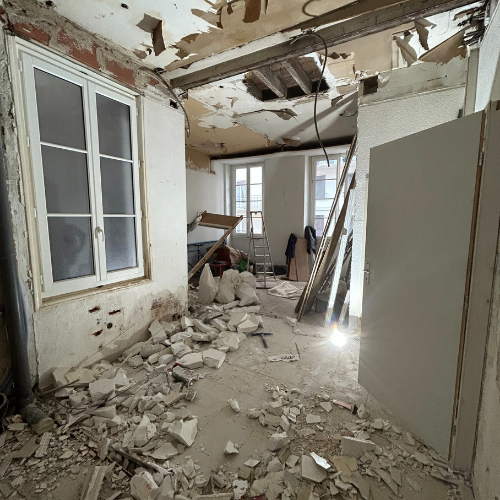 Chantier en cours avec démolition du plafond et gravats au sol